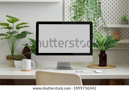 Biophilia workspace in home office room with computer, supplies, decorations and plants house Royalty-Free Stock Photo #1899736342