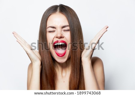 Woman with long hair with wide open mouth and narrowed eyes attractive look 