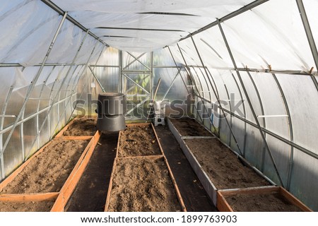 Inside an empty polycarbonate greenhouse. Preparing the greenhouse for sowing Royalty-Free Stock Photo #1899763903