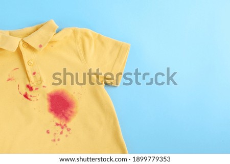dirty stain on clothes. isolated on blue background. space for text. High quality photo Royalty-Free Stock Photo #1899779353