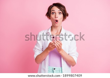 Photo of funny impressed young lady wear white shirt holding modern device isolated pastel pink color background