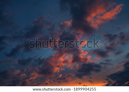 Beautiful dark cloudy sky  at sunset. Evening beauty of orange clouds at sunset. Sky texture, abstract nature background.