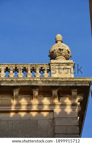 
a decorative fence on the cornice of a historic building and a decorative element on the corner