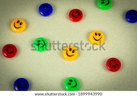 Many funny plastic smiley faces on a light background. The concept of a positive mood