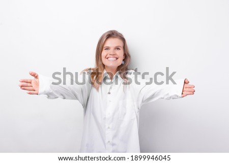 Photo of charming cute young woman making HUG gesture over white background