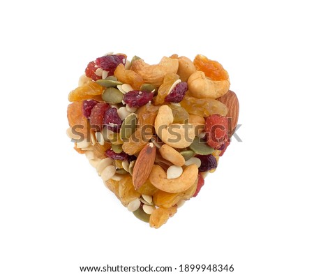 mixed nuts and dried fruits in heart shape isolated on white background, food for health, top view
