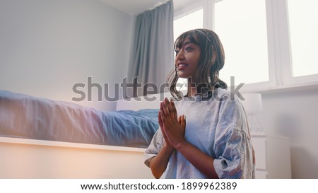 Beautiful young african american black woman meditating in her bedroom. first meditation attempt with smile on her face. High quality photo