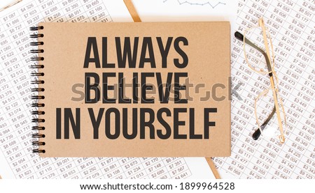 Craft colour notepad with text Always believe in yourself. Notepad with eyeglasses and text documents. Business concept