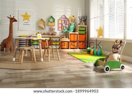 Stylish playroom interior with soft toys and modern furniture Royalty-Free Stock Photo #1899964903