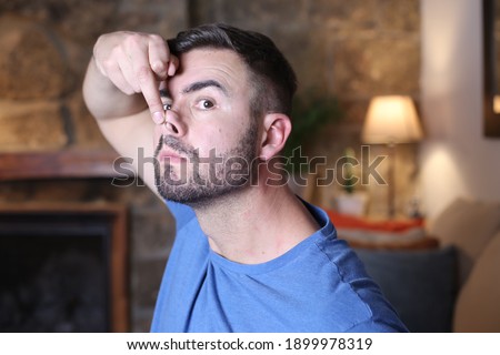 Man elevating nose tip with finger