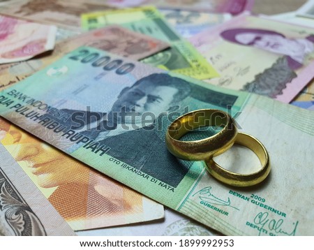A pair of gold rings placed on Indonesia banknotes denote the Day of Love, Valentine day.