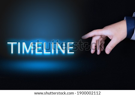 TIMELINE text is a word written in neon letters on a black background pointed to by a hand with a person's index finger.