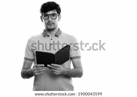 Studio shot of young Persian man holding book