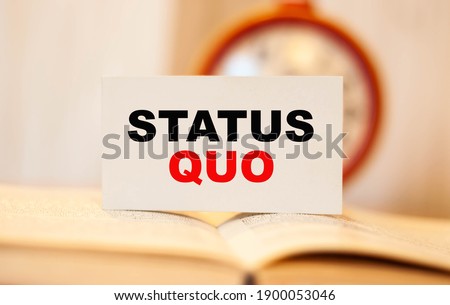 STATUS QUO on the background of a clock on a business card