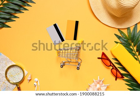 Shopping trolley with credit cards and accessories for sea travel and vacations, glasses, hat, sunscreen. The concept of buying tickets, things, booking hotels for the holidays. Flat lay. top view. 