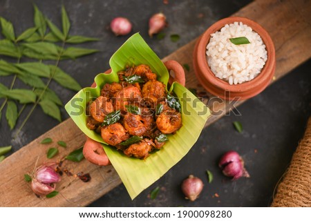 Top view spicy hot Bengali Prawn roast , shrimp masala fish curry. Indian food. Fish fry with red chili, curry leaf. Asian cuisine. Delicious Kerala, Goan fish curry clay pot. Grilled tiger shrimps Royalty-Free Stock Photo #1900098280