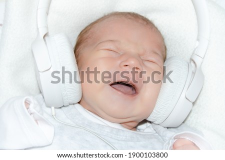 portrait of a baby in a crib,  listening to music on headphones