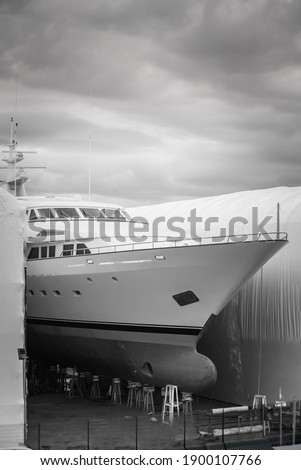 Black and White photo of a hauled out vessel undergoing winter maintenance in shipyard Royalty-Free Stock Photo #1900107766