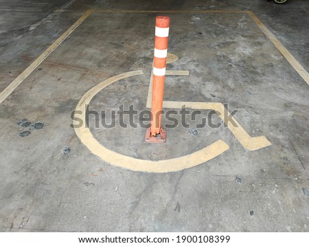 A handicap parking space with stripped iron pole.