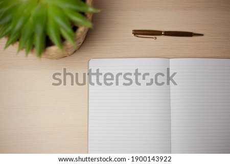 Notebook on desk with a plant