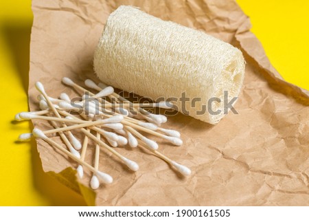 bamboo ear sticks and loofah on craft paper. natural hygiene items. Sustainable sustainable lifestyle. Zero waste concept.