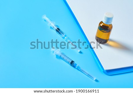 Different medicaments and clipboard with empty paper sheets on blue table. Doctor workplace. Examination in medical university. Diagnosing disease. Workspace in office of medicine supplier