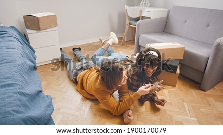 Young multiracial couple moving in together, lying on the floor of new appartment. Buying a new property. . High quality photo