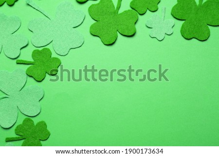 Decorative clover leaves on green background, flat lay with space for text. St. Patrick's Day celebration