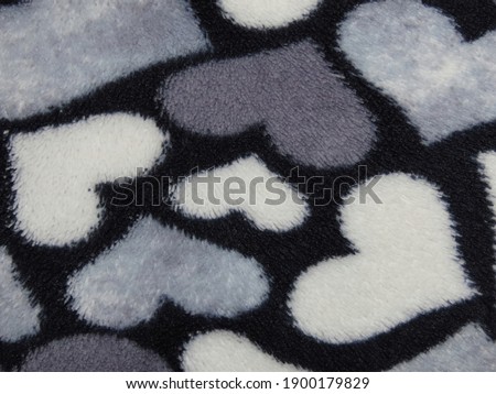 Close-up of dark and white hearts on black synthetics. The photo can be used as a background.