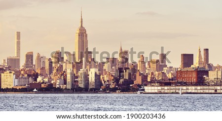 New York City skyline at golden sunset, color toned picture, USA.