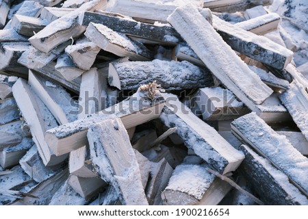 The firewood in the shed is piled up, a supply for the winter. High quality photo
