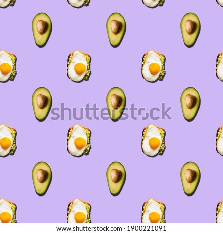 Seamless pattern of sandwich with scrambled eggs and avocado halves on a purple background