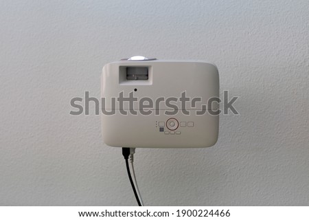 close up white projector hang on ceiling in a room