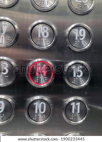 Macro close-up of push buttons in an elevator for levels 10,11,14,15,18,19. Level 14 is highlighted, in red.  Elevator button with number 14 pushed in red colour. 14 February Valentines Day.