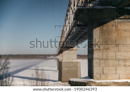 A modern bridge over the frozen north river. Night view