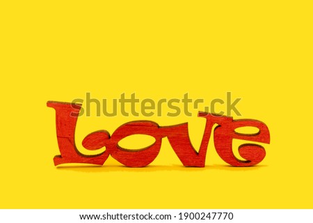 Wooden word Love on a yellow background. Valentine day concept.