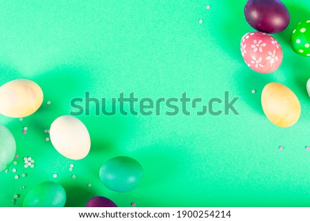 Colorful background with Easter eggs on green background. Happy Easter concept. Can be used as poster, background, holiday card. Flat lay, top view, copy space. 