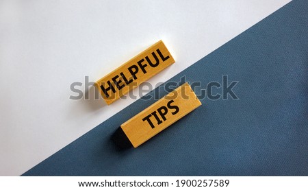 Helpful tips symbol. Wooden blocks with words 'Helpful tips'. Beautiful white and blue background. Business and helpful tips concept. Copy space.