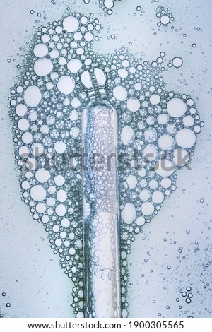 Liquid gel or serum on a screen of microscope gray background
