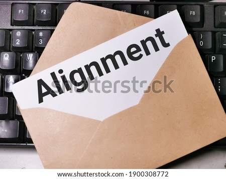Text ALIGNMENT written on white paper note in the envelope on computer keyboard.Business concept.