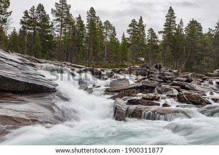 Flat waterfall with many stones in Norway