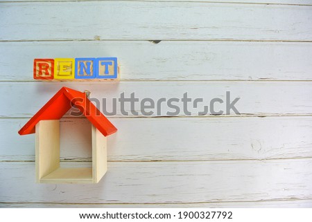Rent word wooden block. Inscription with replica house and fake money. There are several different types of arrangements. Some area had little big noise. Selective focus.