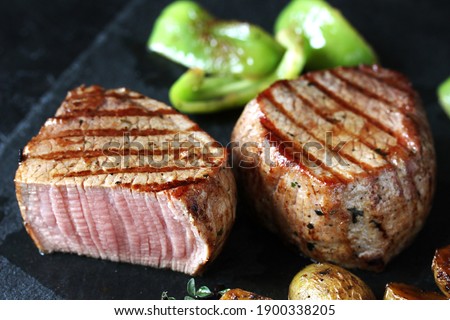 grill filet mignon and vegetables, grilled. steak mignon from the meat of young beef is shown in section, the degree of preparation is "medium"