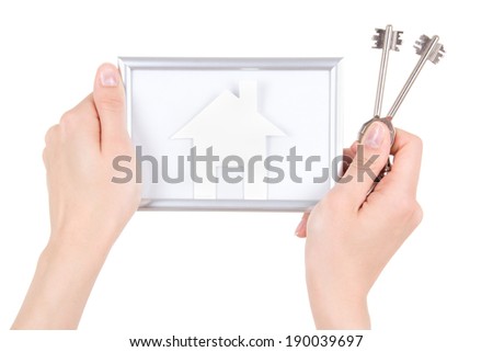 woman hand holding photo frame with paper house and keys isolated on white background
