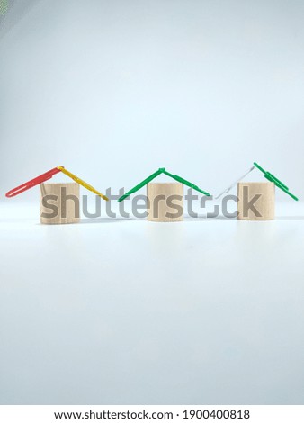 Selective focus.A simple house made from a block cylinder with paper clips on a white background.Copy and text space concept idea.Shot were noise and film grain.
