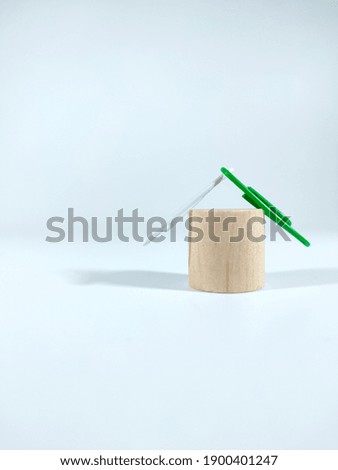 Selective focus.A simple house made from a block cylinder with paper clips on a white background.Property and text space concept idea.Shot were noise and film grain.