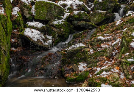 Small creek near Zlata Koruna village with green moss stone in winter cold day in south Bohemia region