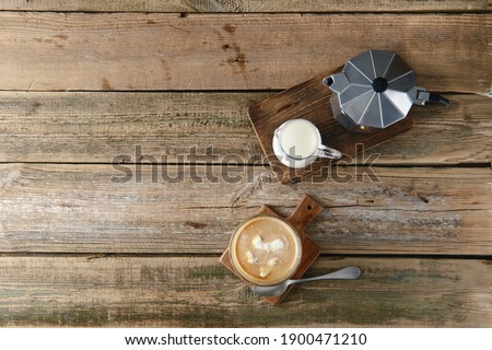 Top view of iced coffee with milk ice cubes on wooden table