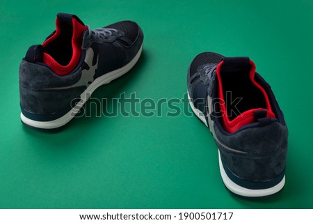 A pair of men's insulated sneakers close-up on a green background.