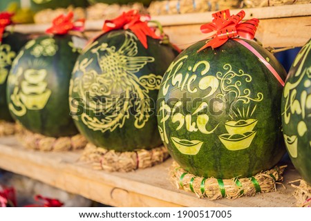 Water melons with festive engraving on Tet Eve. Tet is Lunar New Year and celebrated during four days in Vietnam TEXT TRANSLATION from Vietnamese: Congratulations on the Vietnamese, Chinese New Years